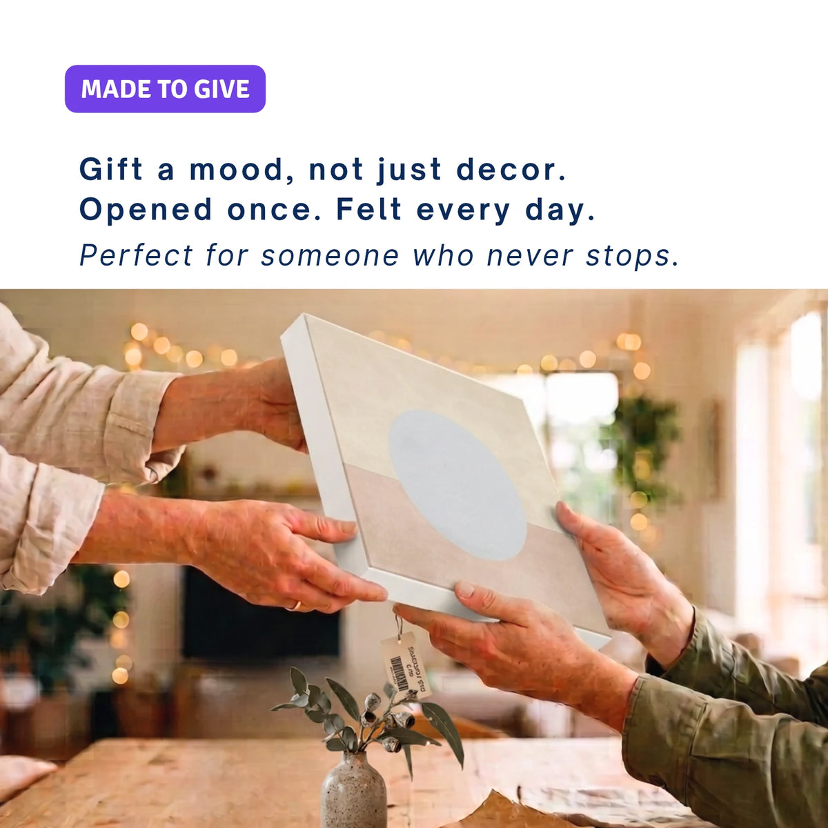 Christmas canvas wall art gift: hands passing ENOUGH Moon across a table, fairy lights behind