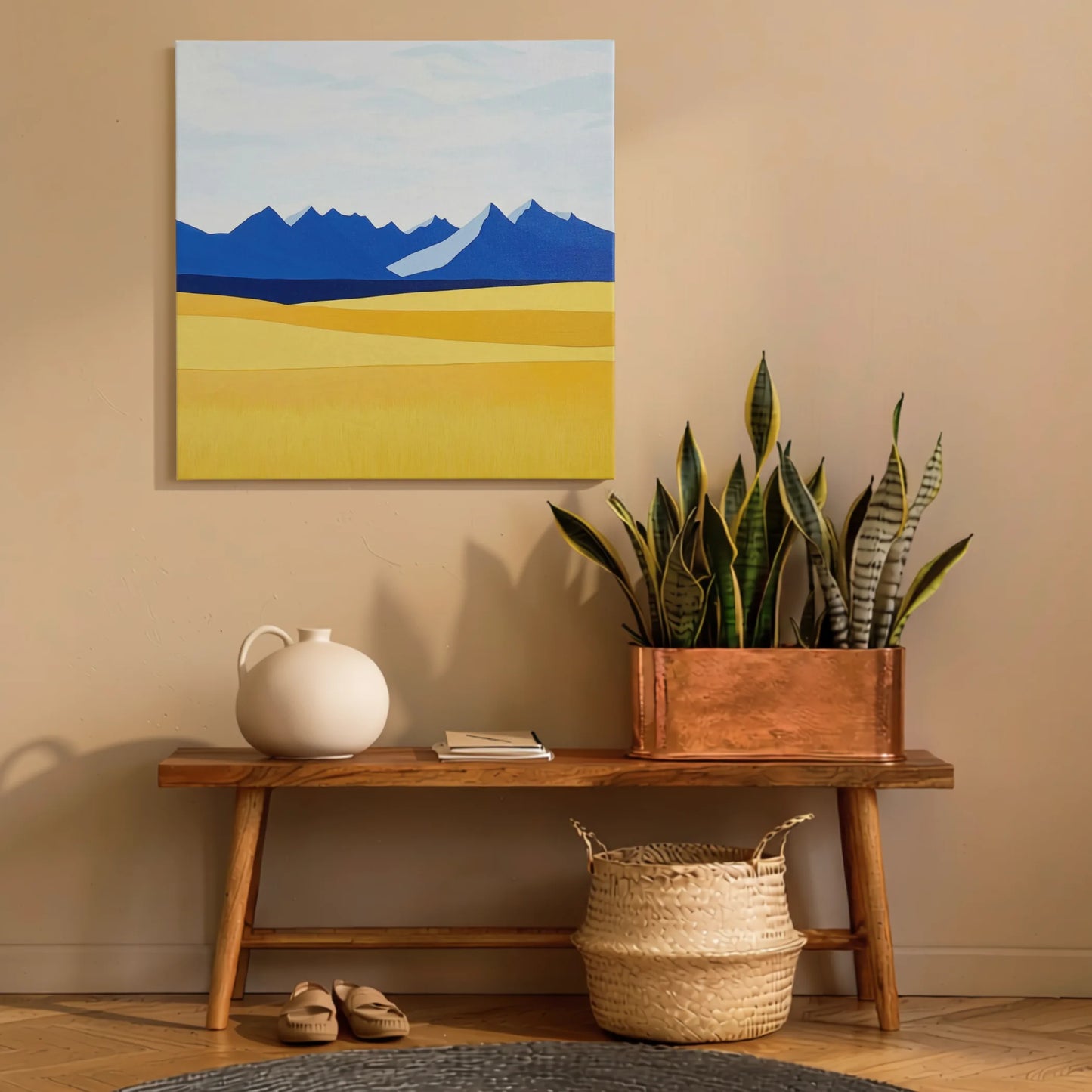 Landscape wall art mountain print in hallway above timber console with snake plant and woven basket