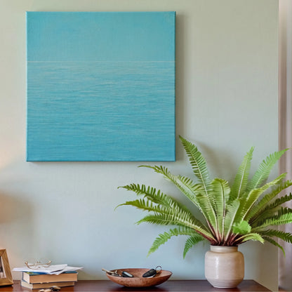 Navy blue wall art ocean canvas in entryway with white console table, potted plant, and warm downlighting