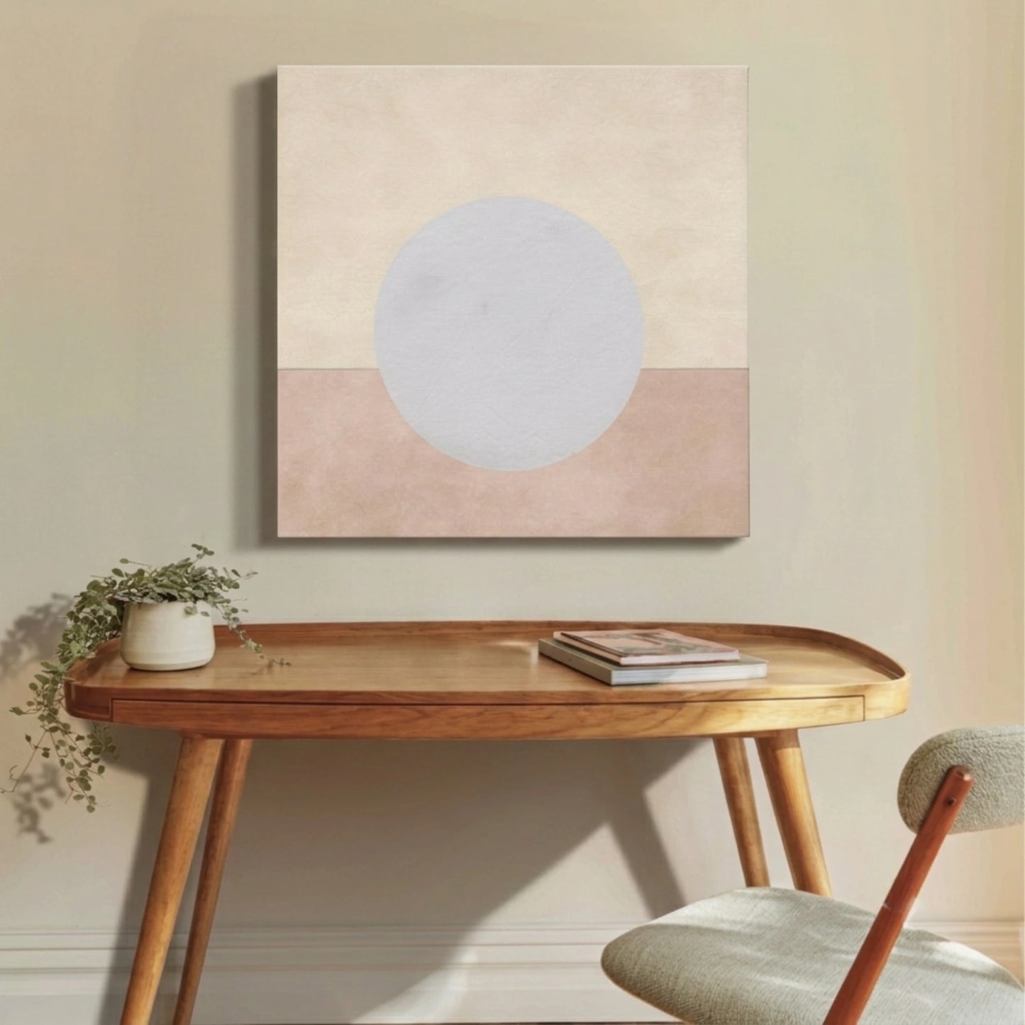 neutral wall art moon canvas above work desk with open book and soft neutral tones