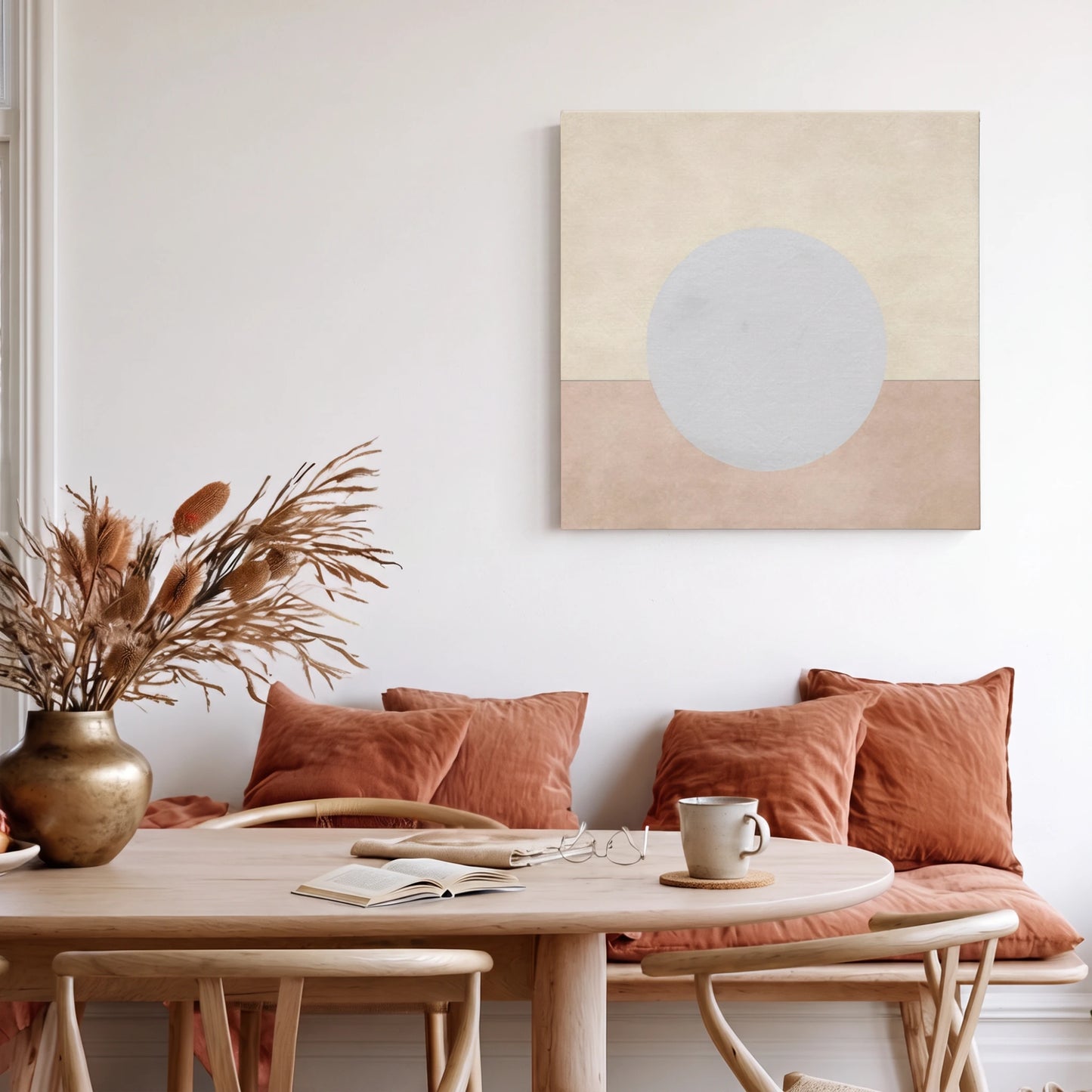 Peaceful wall art moon canvas in warm dining area with terracotta cushions and dried pampas