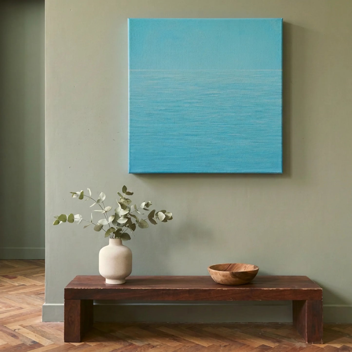 Peaceful wall art ocean canvas in hallway with dark timber side table, white florals, and sage green wall